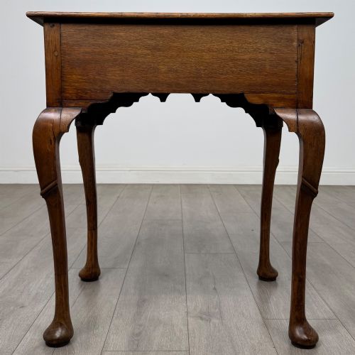 fig 4. An 18th-century Georgian oak side table featuring a single drawer with geometric inlaid border, lion mask brass ring handles, shaped apron, and four cabriole legs ending in pad feet.