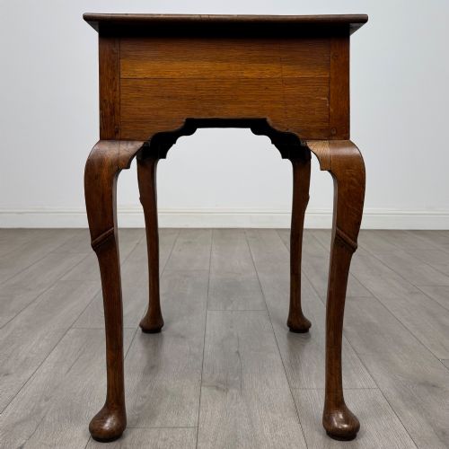 fig 6. An 18th-century Georgian oak side table featuring a single drawer with geometric inlaid border, lion mask brass ring handles, shaped apron, and four cabriole legs ending in pad feet.