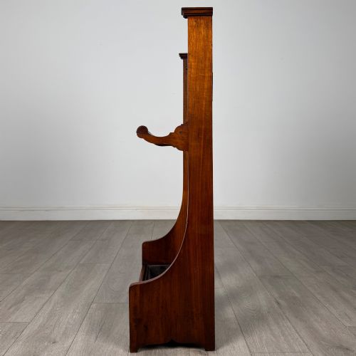 fig 2. An Edwardian walnut hall stand featuring a fluted central column, metal coat hooks, a horizontal umbrella rail, and a metal drip tray at the base.