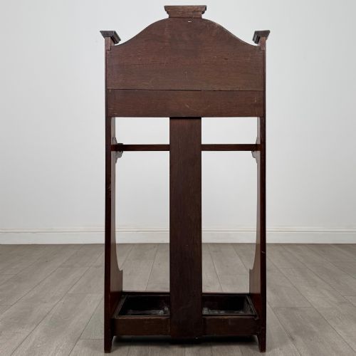 fig 4. An Edwardian walnut hall stand featuring a fluted central column, metal coat hooks, a horizontal umbrella rail, and a metal drip tray at the base.