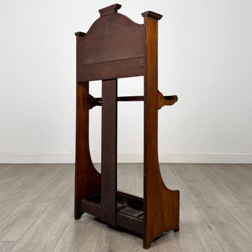 fig 5. An Edwardian walnut hall stand featuring a fluted central column, metal coat hooks, a horizontal umbrella rail, and a metal drip tray at the base.