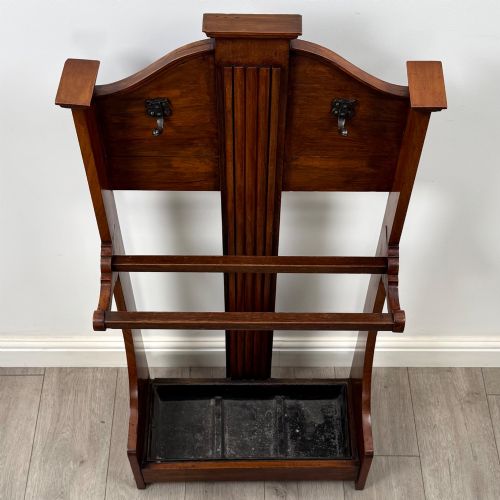 fig 8. An Edwardian walnut hall stand featuring a fluted central column, metal coat hooks, a horizontal umbrella rail, and a metal drip tray at the base.