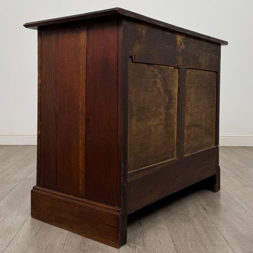 fig 3. An antique Edwardian dark oak chest of drawers featuring two small top drawers above two full-width drawers with brass handles.
