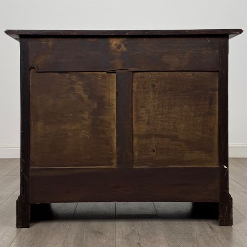 fig 4. An antique Edwardian dark oak chest of drawers featuring two small top drawers above two full-width drawers with brass handles.