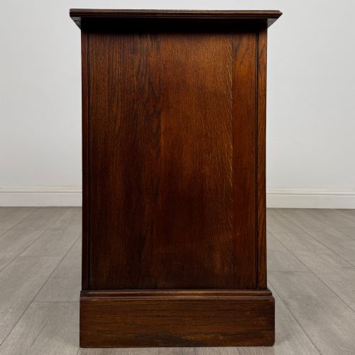fig 6. An antique Edwardian dark oak chest of drawers featuring two small top drawers above two full-width drawers with brass handles.