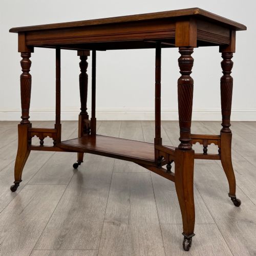fig 1. An Edwardian walnut side table featuring turned spiral legs, a lower shelf, carved corner brackets, and metal castors.