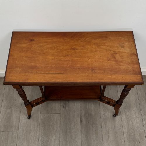 fig 8. An Edwardian walnut side table featuring turned spiral legs, a lower shelf, carved corner brackets, and metal castors.