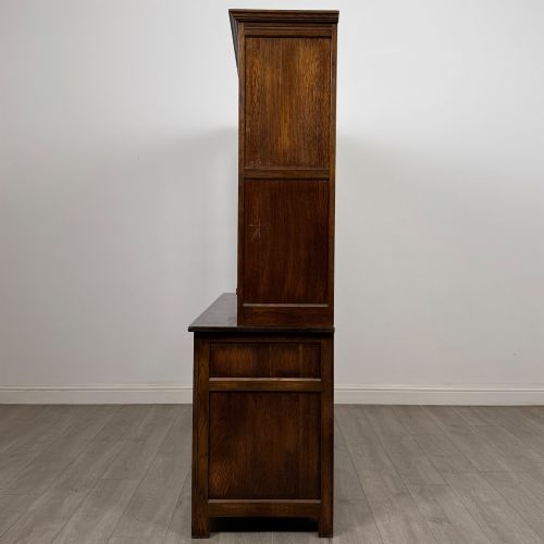 fig 3. A large dark oak display cabinet featuring three leaded glass doors above three drawers and three panelled cupboard doors.