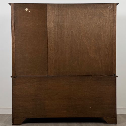 fig 5. A large dark oak display cabinet featuring three leaded glass doors above three drawers and three panelled cupboard doors.