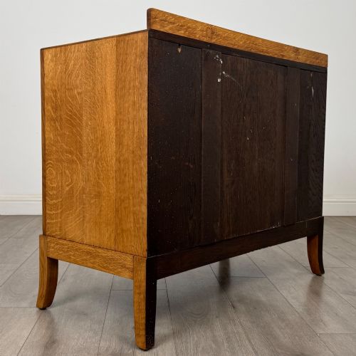 fig 3. A golden oak chest of drawers featuring two short drawers over two long drawers with brass ring handles.