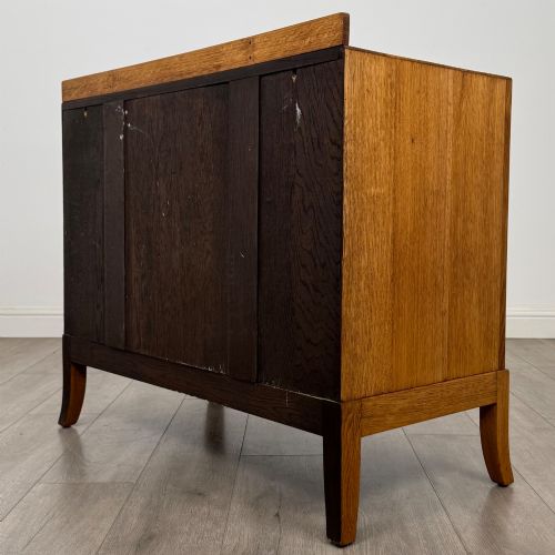 fig 5. A golden oak chest of drawers featuring two short drawers over two long drawers with brass ring handles.