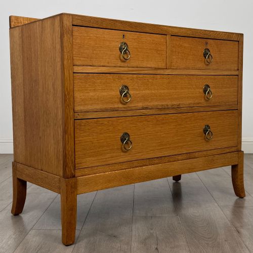 fig 7. A golden oak chest of drawers featuring two short drawers over two long drawers with brass ring handles.