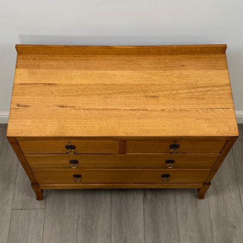 fig 8. A golden oak chest of drawers featuring two short drawers over two long drawers with brass ring handles.
