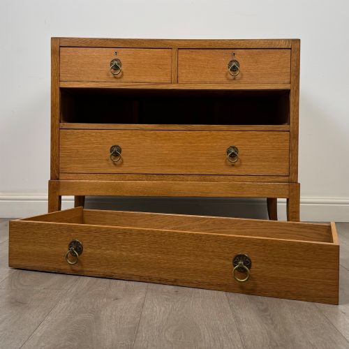 fig 9. A golden oak chest of drawers featuring two short drawers over two long drawers with brass ring handles.