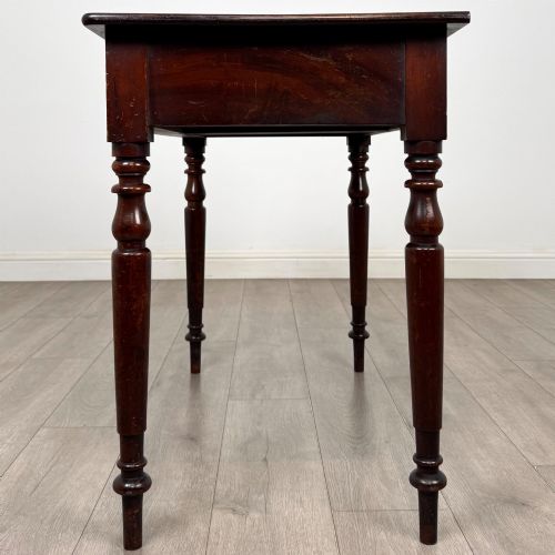 fig 2. A Victorian dark mahogany writing table with two drawers, turned wooden knob handles, keyhole escutcheons, and four turned legs.