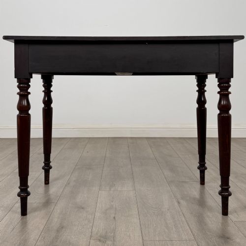 fig 4. A Victorian dark mahogany writing table with two drawers, turned wooden knob handles, keyhole escutcheons, and four turned legs.