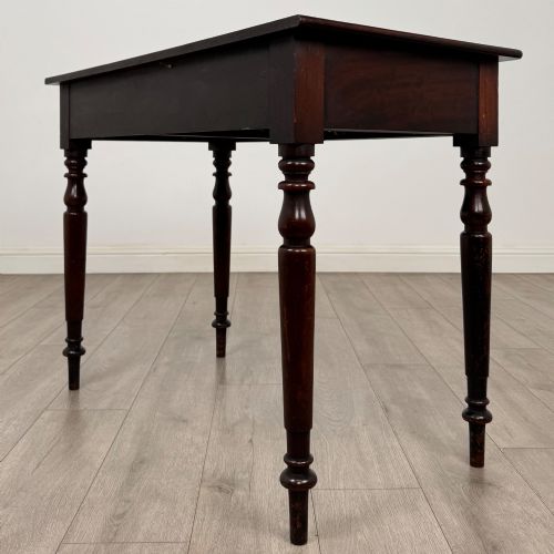 fig 5. A Victorian dark mahogany writing table with two drawers, turned wooden knob handles, keyhole escutcheons, and four turned legs.