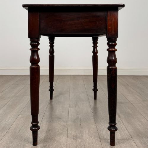 fig 6. A Victorian dark mahogany writing table with two drawers, turned wooden knob handles, keyhole escutcheons, and four turned legs.