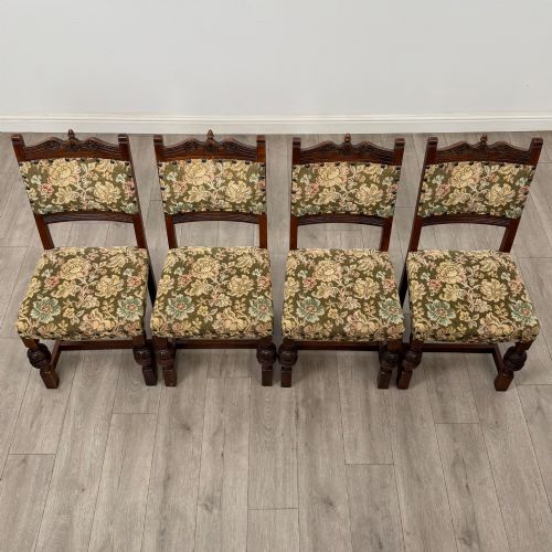 fig 7. A set of six dark oak dining chairs with carved crest rails, floral tapestry upholstered backrests and seats, and turned front legs.