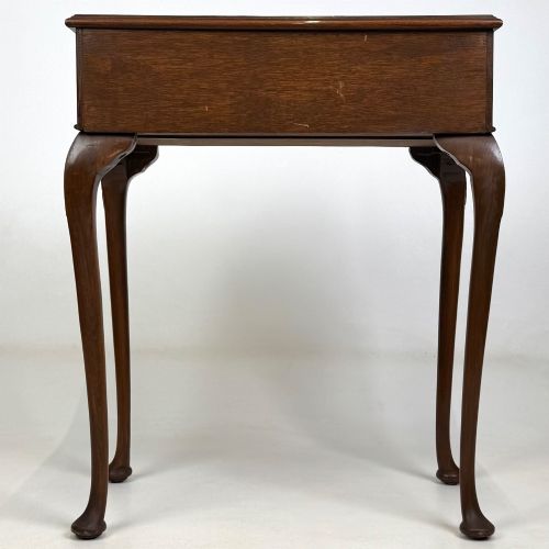 fig 4. An Edwardian side table crafted from warm brown figured walnut featuring a single drawer with ornate brass handles and carved cabriole legs.