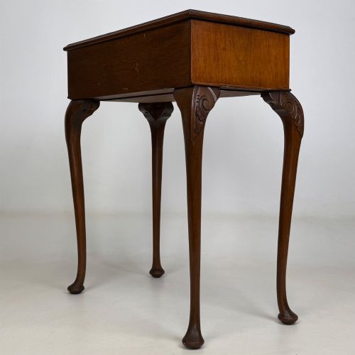 fig 5. An Edwardian side table crafted from warm brown figured walnut featuring a single drawer with ornate brass handles and carved cabriole legs.