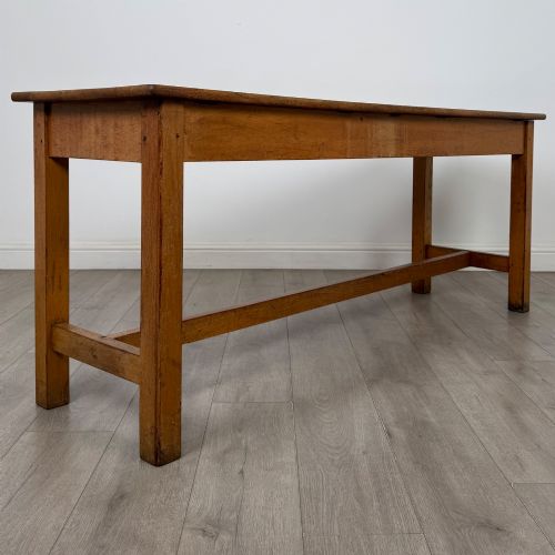 fig 3. A long 20th century oak side table featuring a plain rectangular top, four square legs, and a low central stretcher.