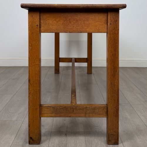 fig 6. A long 20th century oak side table featuring a plain rectangular top, four square legs, and a low central stretcher.