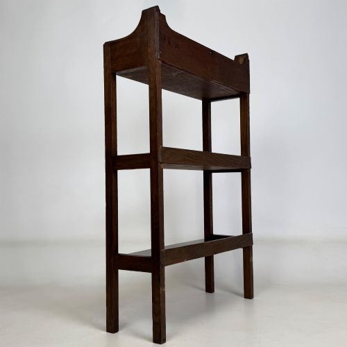 fig 4. An early 20th-century Arts and Crafts solid oak open bookcase featuring three fixed shelves and a shaped gallery backboard with a cutout heart motif.