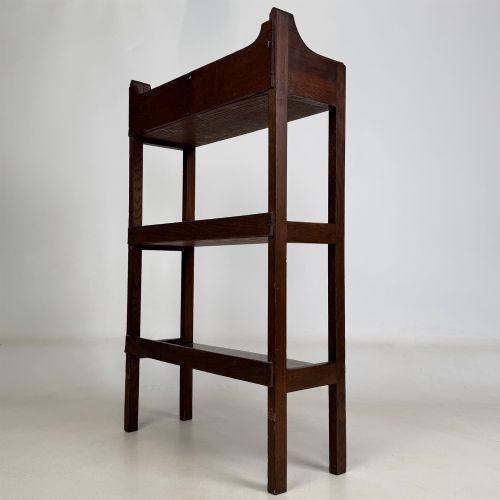 fig 6. An early 20th-century Arts and Crafts solid oak open bookcase featuring three fixed shelves and a shaped gallery backboard with a cutout heart motif.