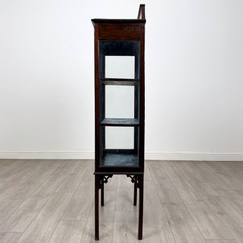 fig 3. A slender Edwardian mahogany glazed display cabinet featuring astragal door bars and a fabric-lined interior raised on square legs.