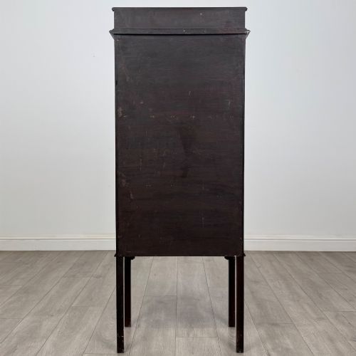 fig 5. A slender Edwardian mahogany glazed display cabinet featuring astragal door bars and a fabric-lined interior raised on square legs.