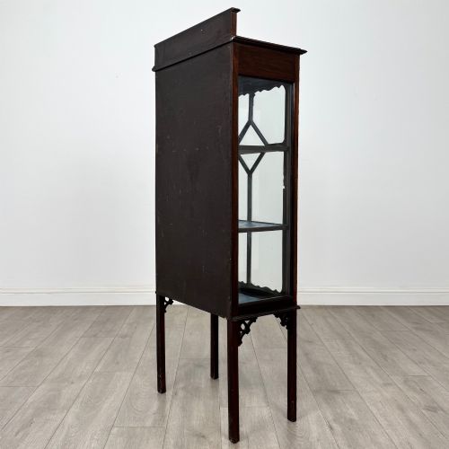 fig 6. A slender Edwardian mahogany glazed display cabinet featuring astragal door bars and a fabric-lined interior raised on square legs.