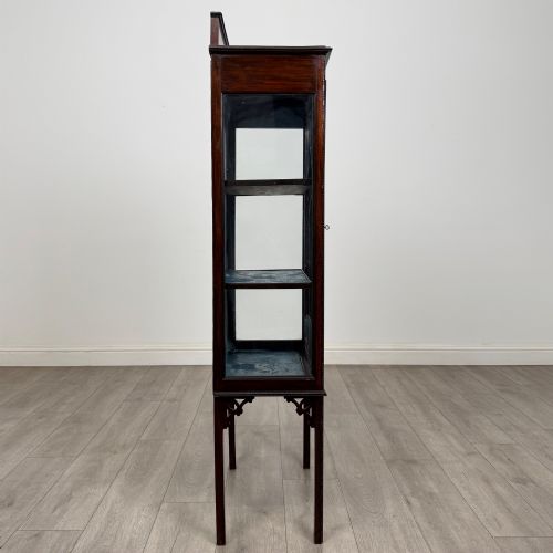 fig 7. A slender Edwardian mahogany glazed display cabinet featuring astragal door bars and a fabric-lined interior raised on square legs.