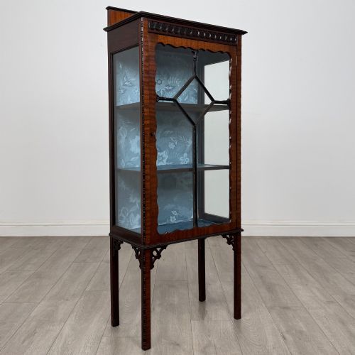 fig 8. A slender Edwardian mahogany glazed display cabinet featuring astragal door bars and a fabric-lined interior raised on square legs.