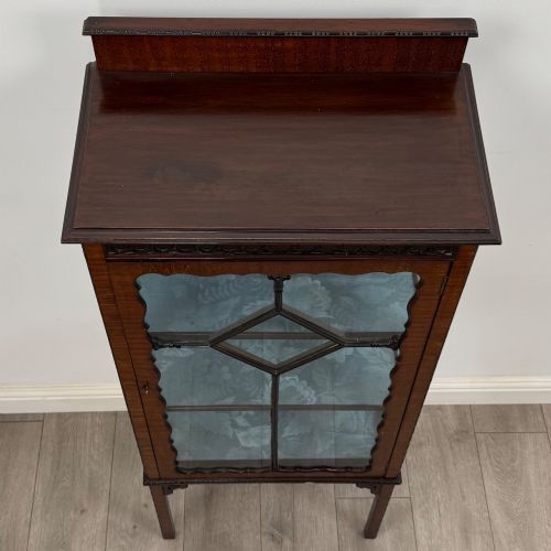 fig 9. A slender Edwardian mahogany glazed display cabinet featuring astragal door bars and a fabric-lined interior raised on square legs.