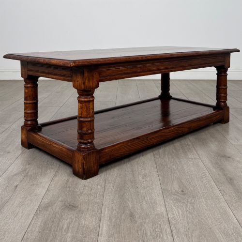 fig 3. A low rectangular dark oak coffee table featuring turned legs and a solid lower shelf.