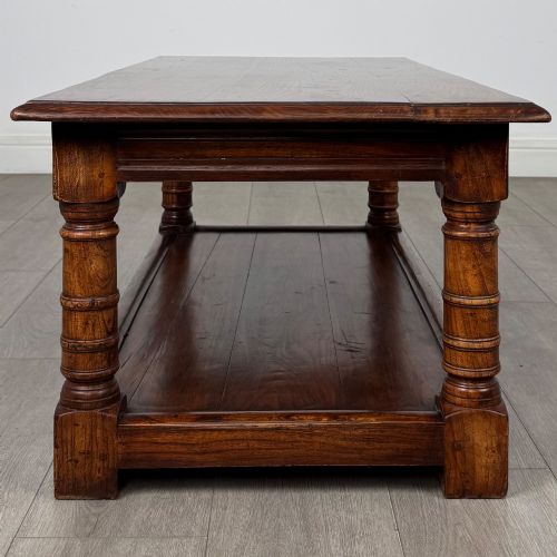 fig 6. A low rectangular dark oak coffee table featuring turned legs and a solid lower shelf.