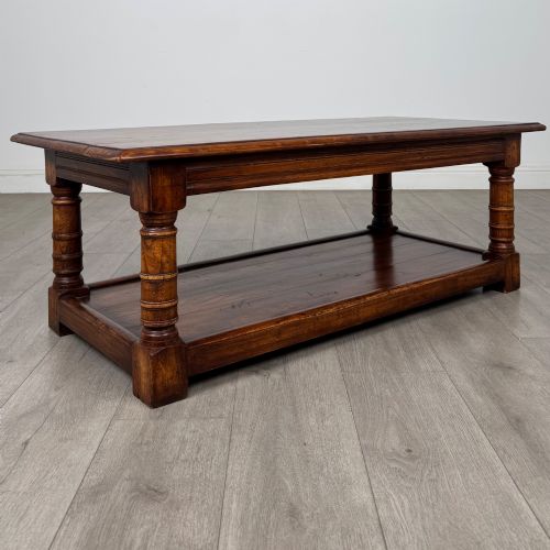 fig 7. A low rectangular dark oak coffee table featuring turned legs and a solid lower shelf.