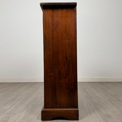 fig 2. A tall dark brown hardwood chest of drawers featuring five horizontal drawers fitted with metal ring pull handles.