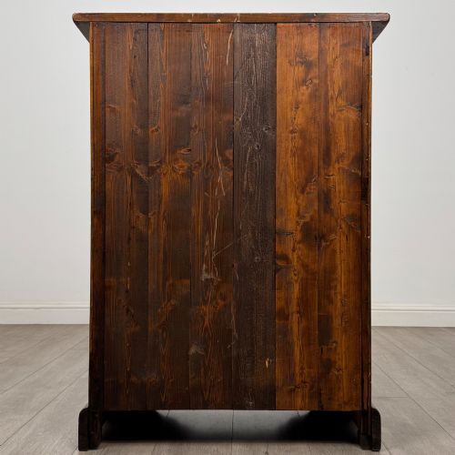 fig 4. A tall dark brown hardwood chest of drawers featuring five horizontal drawers fitted with metal ring pull handles.