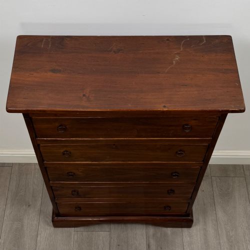 fig 8. A tall dark brown hardwood chest of drawers featuring five horizontal drawers fitted with metal ring pull handles.