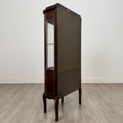 fig 4. A French mahogany display vitrine featuring a curved glass door, red fabric interior lining, floral marquetry lower panel, and brass leg mounts.