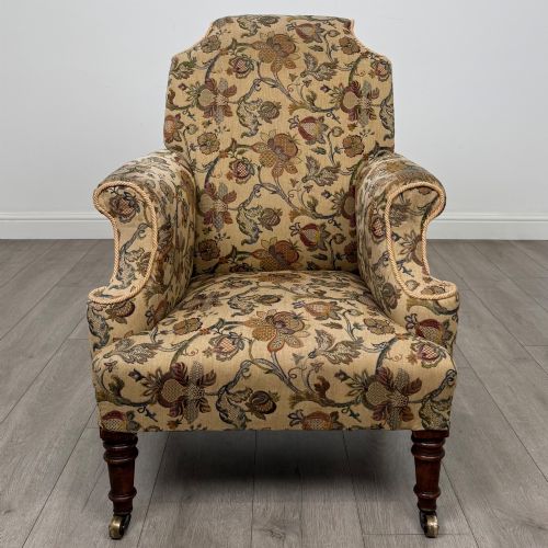 fig 7. A 19th-century wingback armchair upholstered in floral tapestry fabric with turned mahogany front legs on brass castors.