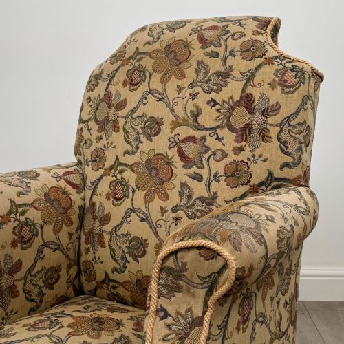 fig 9. A 19th-century wingback armchair upholstered in floral tapestry fabric with turned mahogany front legs on brass castors.