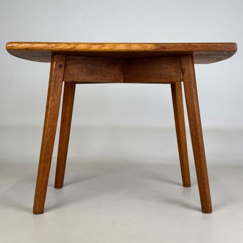 fig 4. A rectangular golden oak coffee table with tapered splayed legs and visible wooden peg joinery.
