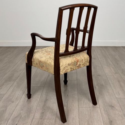 fig 2. A set of six dark mahogany dining chairs featuring carved vertical back splats, square tapered legs, and floral upholstered seats.
