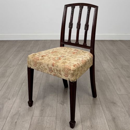 fig 3. A set of six dark mahogany dining chairs featuring carved vertical back splats, square tapered legs, and floral upholstered seats.