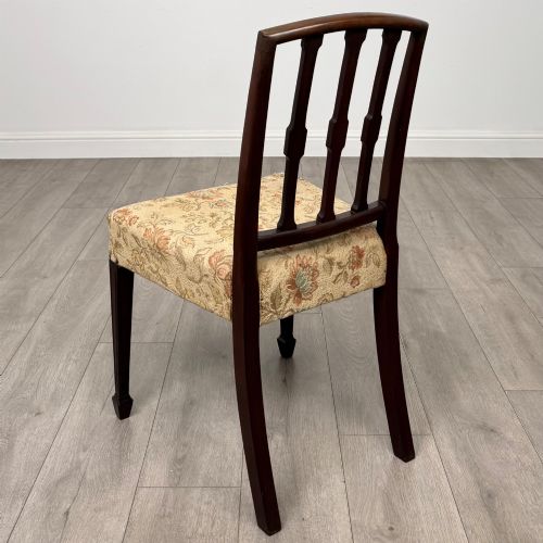 fig 4. A set of six dark mahogany dining chairs featuring carved vertical back splats, square tapered legs, and floral upholstered seats.