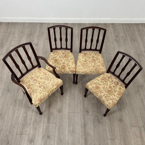 fig 8. A set of six dark mahogany dining chairs featuring carved vertical back splats, square tapered legs, and floral upholstered seats.