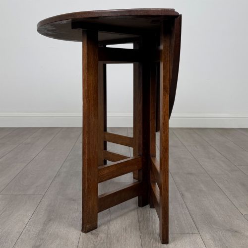 fig 2. An early 20th-century Arts and Crafts solid oak gateleg table featuring drop leaves and a geometric trestle base.